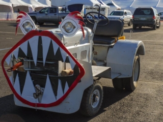 An airplane tug sits parked with a comical face on it.