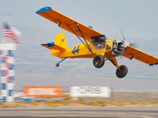 An airplane flies at an unusual angle past home pylon.
