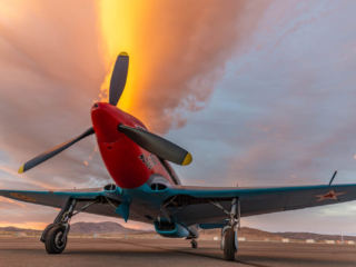 An airplane sits on a runway at sunset.