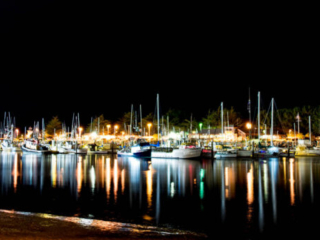 A photo of boats docked in the harbor at night