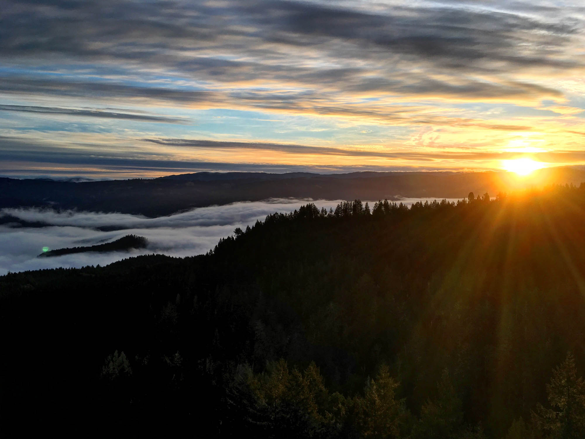 The sun rises over a foggy valley